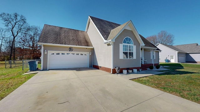 view of front of home featuring a shingled roof, fence, a front yard, driveway, and an attached garage