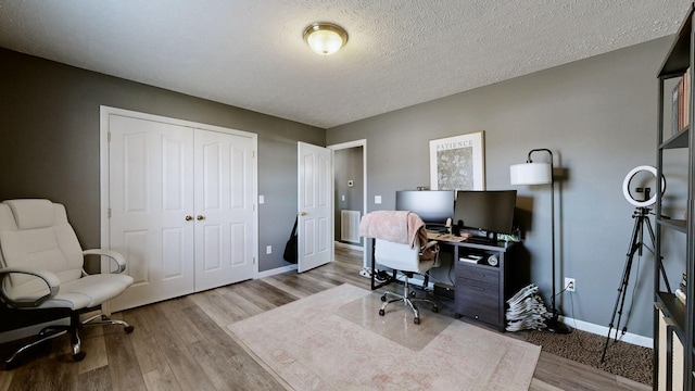 office featuring baseboards, a textured ceiling, and wood finished floors