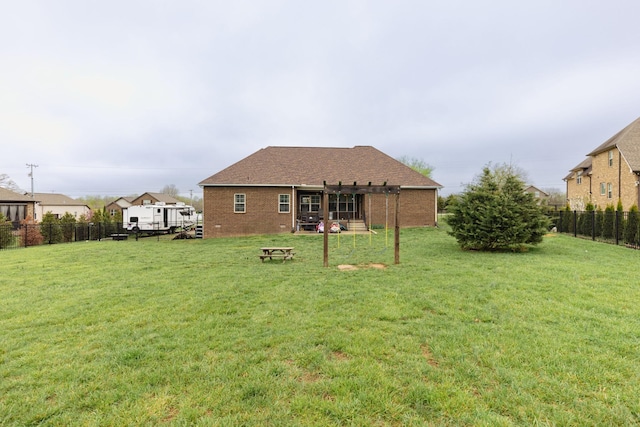 back of house featuring a lawn, brick siding, a fenced backyard, and a pergola