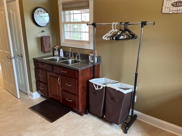 bathroom featuring baseboards and a sink
