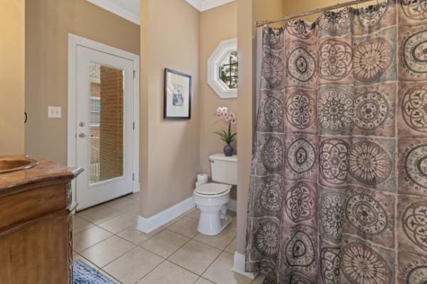 bathroom featuring tile patterned floors, toilet, baseboards, vanity, and ornamental molding