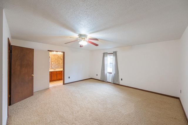 unfurnished room featuring light colored carpet, a textured ceiling, baseboards, and a ceiling fan