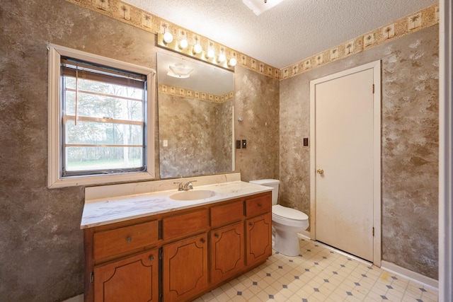 bathroom with baseboards, toilet, vanity, tile patterned floors, and a textured ceiling