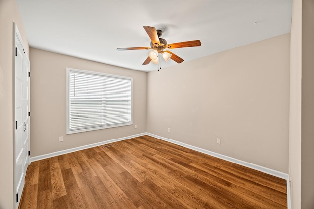 unfurnished room with visible vents, a ceiling fan, baseboards, and wood finished floors