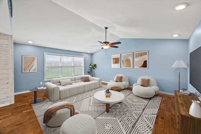 living area with baseboards, wood finished floors, a ceiling fan, and vaulted ceiling
