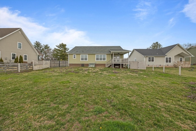 back of property featuring crawl space, a lawn, and a fenced backyard