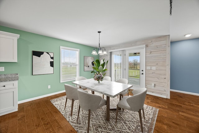 dining room featuring plenty of natural light, baseboards, and dark wood-style flooring