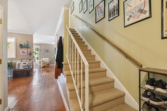 stairway featuring ornamental molding, baseboards, and hardwood / wood-style floors