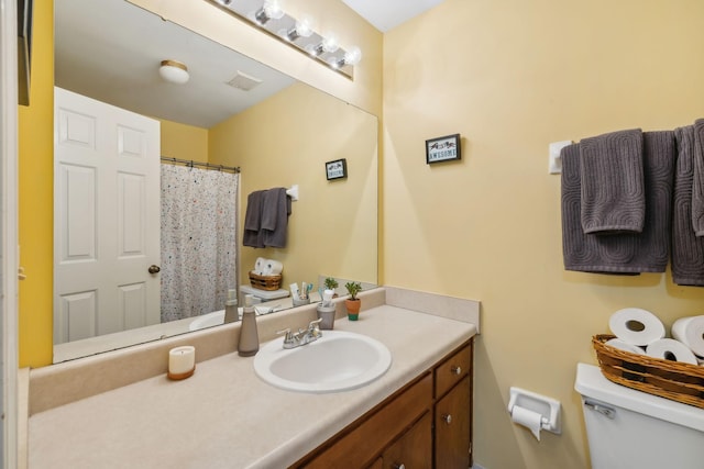 bathroom featuring vanity, toilet, and visible vents