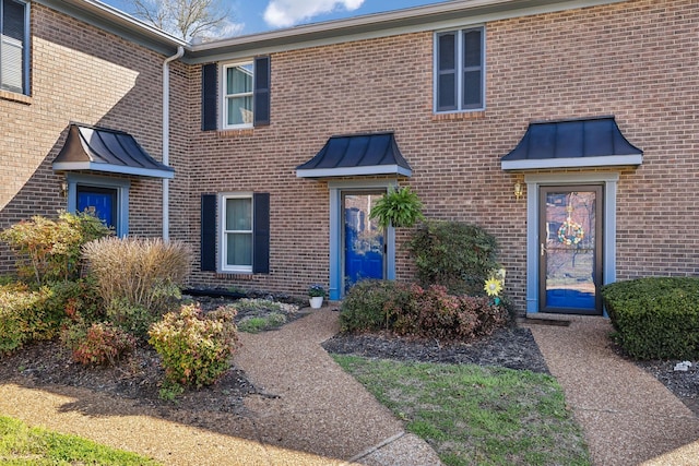 entrance to property featuring brick siding