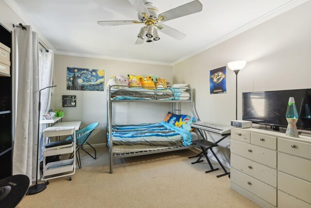 carpeted bedroom with baseboards, crown molding, and a ceiling fan