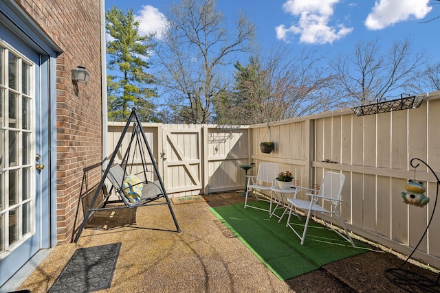 view of yard featuring a patio area, a fenced backyard, and a gate
