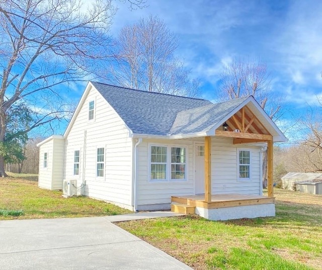 view of front of home featuring a front lawn and roof with shingles
