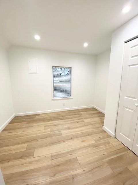 spare room featuring recessed lighting, light wood-style flooring, and baseboards