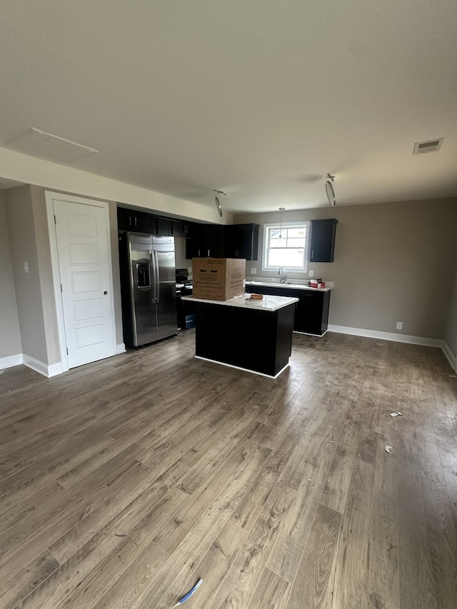 150 Cardinal Crk, Clarksville, TN 37040 - kitchen with stainless steel fridge with ice dispenser, a kitchen island, dark cabinets, open floor plan, and dark wood finished floors