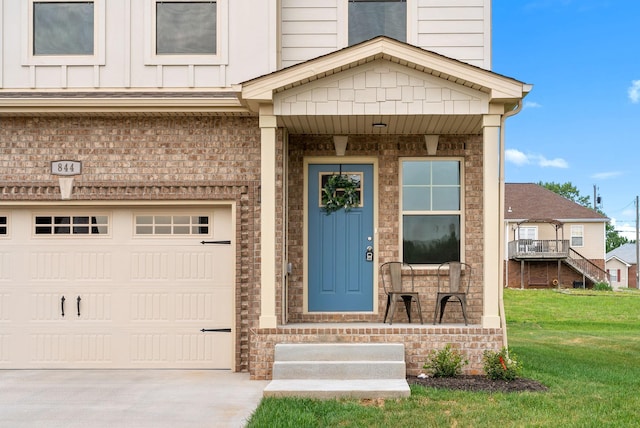 150 Cardinal Crk, Clarksville, TN 37040 - view of exterior entry with a lawn, driveway, a garage, brick siding, and a porch