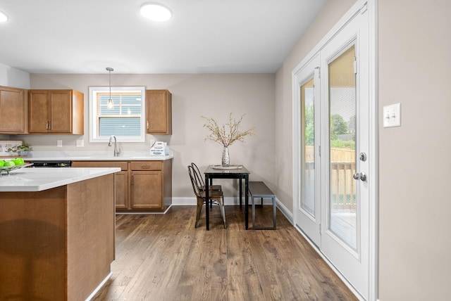 150 Cardinal Crk, Clarksville, TN 37040 - kitchen with a sink, brown cabinets, dark wood-type flooring, light countertops, and hanging light fixtures