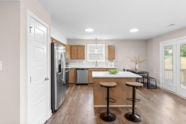 150 Cardinal Crk, Clarksville, TN 37040 - kitchen with appliances with stainless steel finishes, a sink, light countertops, wood finished floors, and a kitchen island