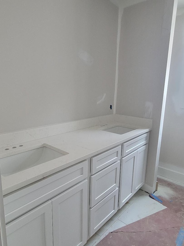 bathroom with marble finish floor and a sink