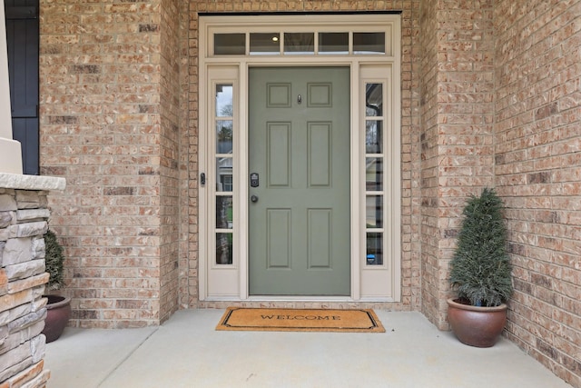view of exterior entry featuring brick siding