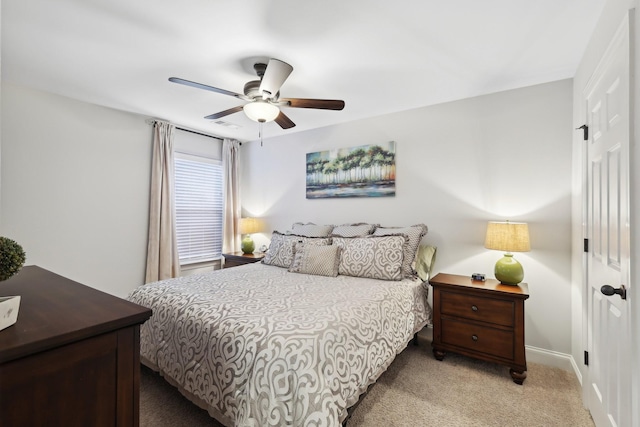 bedroom with baseboards, light colored carpet, a closet, and ceiling fan