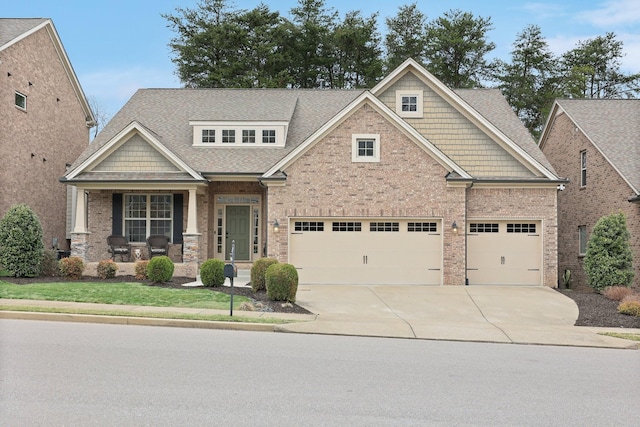 craftsman inspired home with concrete driveway, brick siding, covered porch, and roof with shingles