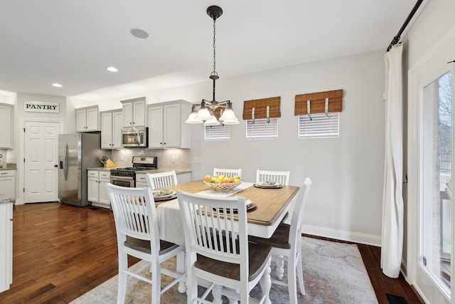 dining area featuring visible vents, dark wood-type flooring, baseboards, recessed lighting, and a notable chandelier