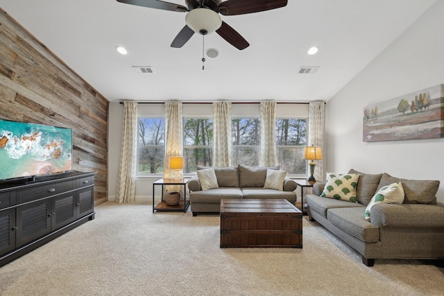carpeted living area with recessed lighting, visible vents, wooden walls, and a ceiling fan