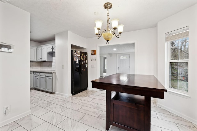 dining room featuring an inviting chandelier, baseboards, marble finish floor, and a textured ceiling