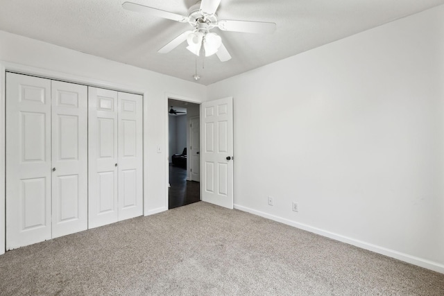 unfurnished bedroom featuring a closet, a ceiling fan, baseboards, and carpet floors