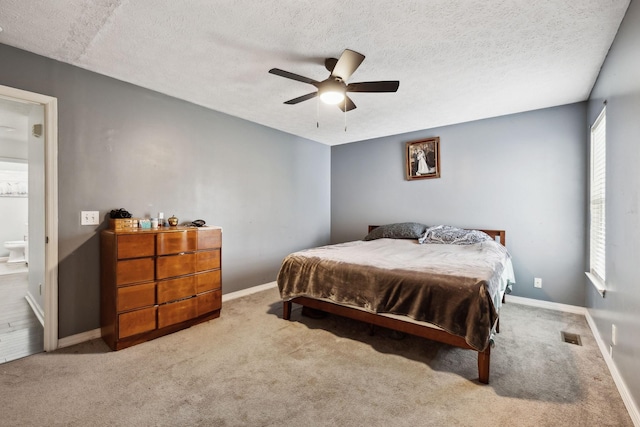 carpeted bedroom featuring multiple windows, a textured ceiling, and baseboards