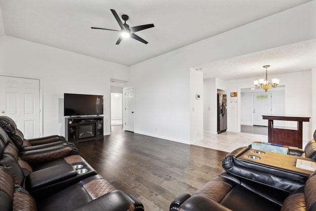 living room featuring baseboards, wood finished floors, and ceiling fan with notable chandelier