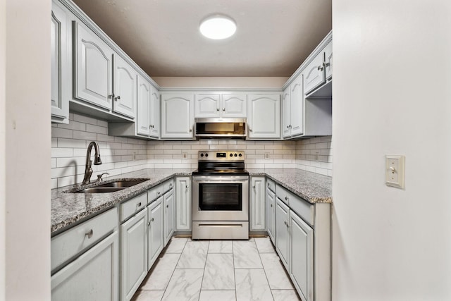 kitchen with tasteful backsplash, light stone countertops, marble finish floor, stainless steel appliances, and a sink