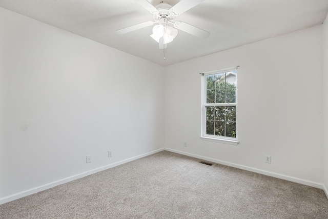carpeted empty room with visible vents, baseboards, and ceiling fan
