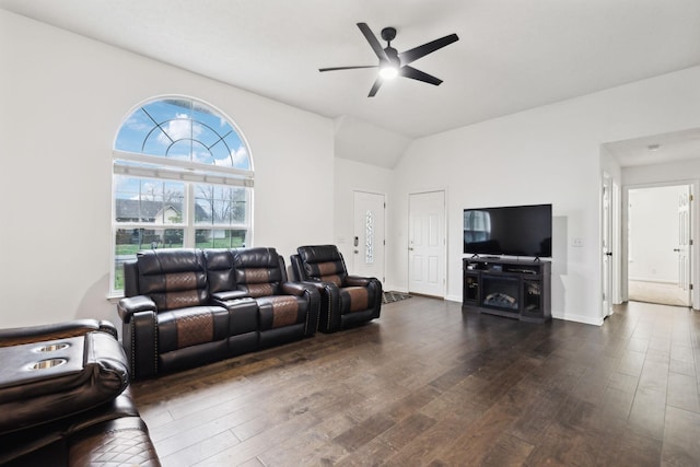 living area with baseboards, a ceiling fan, and dark wood-style flooring