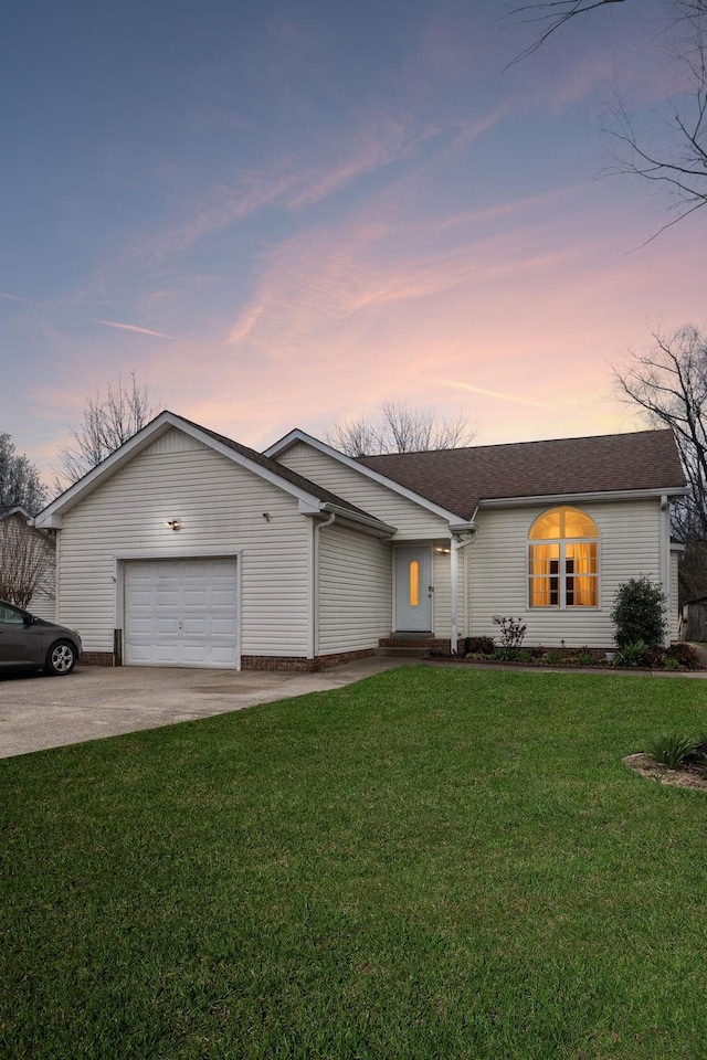 view of front facade featuring concrete driveway, a lawn, and a garage