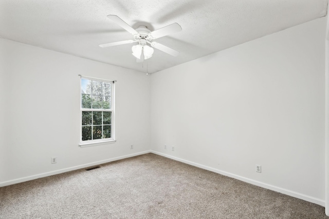unfurnished room featuring visible vents, a textured ceiling, a ceiling fan, and carpet