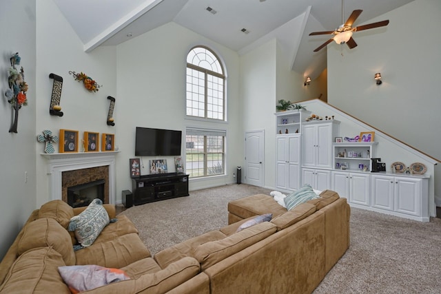living area featuring high vaulted ceiling, visible vents, light carpet, and a ceiling fan