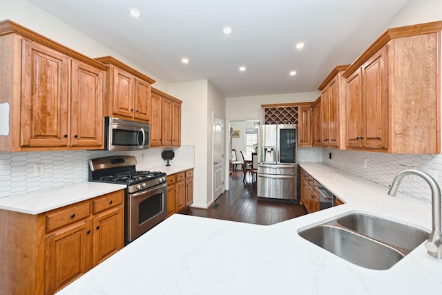 kitchen featuring a sink, recessed lighting, stainless steel appliances, dark wood-type flooring, and decorative backsplash