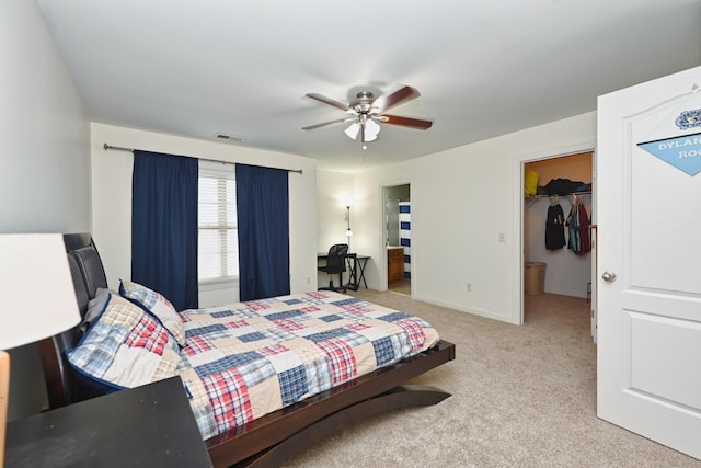 carpeted bedroom featuring a spacious closet, visible vents, and a ceiling fan