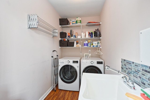 laundry room with baseboards, independent washer and dryer, laundry area, a sink, and wood finished floors
