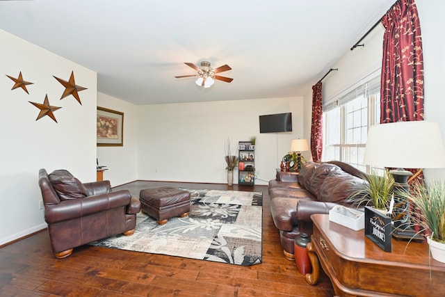 living area with baseboards, hardwood / wood-style flooring, and a ceiling fan