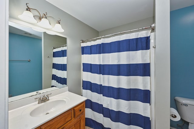 full bathroom featuring curtained shower, vanity, and toilet