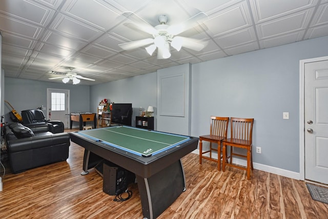 playroom with wood finished floors, ceiling fan, baseboards, and an ornate ceiling