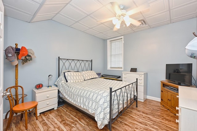 bedroom with baseboards, a ceiling fan, and light wood-style floors