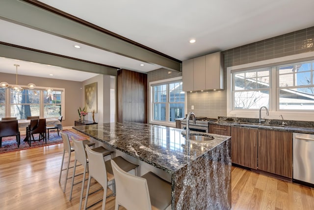 1926 20th Ave S, Nashville, TN 37212 - kitchen featuring light wood-type flooring, dark stone counters, a sink, modern cabinets, and appliances with stainless steel finishes