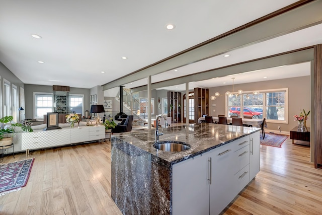 1926 20th Ave S, Nashville, TN 37212 - kitchen with dark stone counters, light wood-style flooring, a sink, and open floor plan