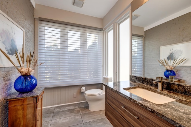 1926 20th Ave S, Nashville, TN 37212 - bathroom featuring brick wall, toilet, tile patterned flooring, and vanity