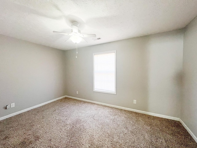 carpeted empty room with baseboards, visible vents, a textured ceiling, and a ceiling fan