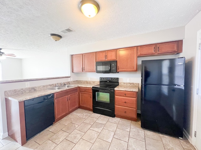kitchen with visible vents, light countertops, a peninsula, black appliances, and a sink